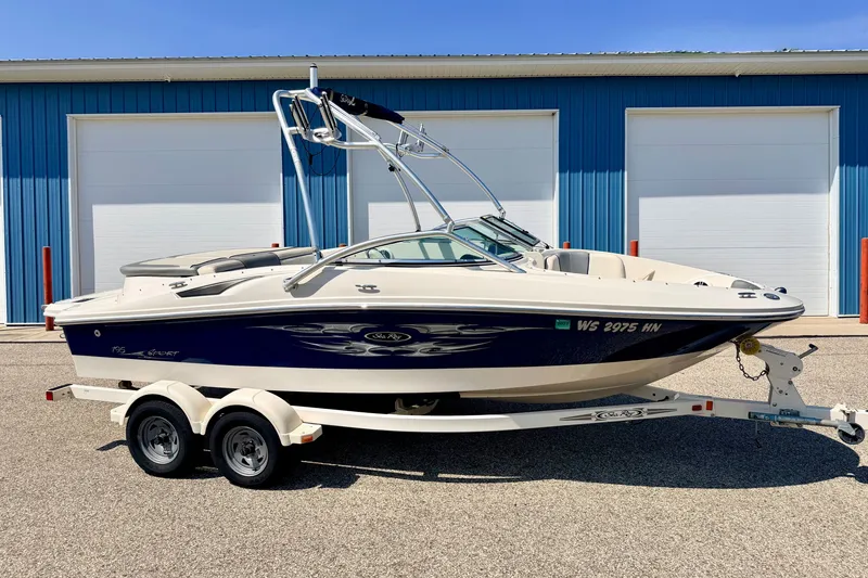The Image of 2008 Sea Ray 195 Sport boat on trailer, parked in front of blue garage doors. - 1