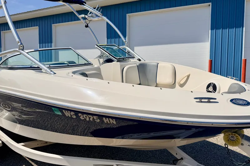 Slide: The Image of 2008 Sea Ray 195 Sport boat with sleek design, parked near blue building. - 15