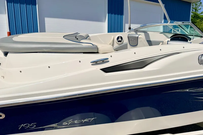 Slide: The Image of 2008 Sea Ray 195 Sport boat with sleek white and blue design, docked outdoors. - 14