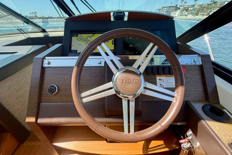 Slide: The Image of Steering wheel and dashboard of a 2015 Tiara Yachts 50 Coupe, featuring navigation display. - 39