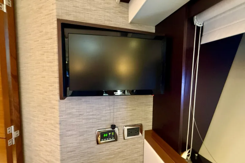 Slide: The Image of Flat-screen TV and control panel inside 2015 Tiara Yachts 50 Coupe interior. - 65
