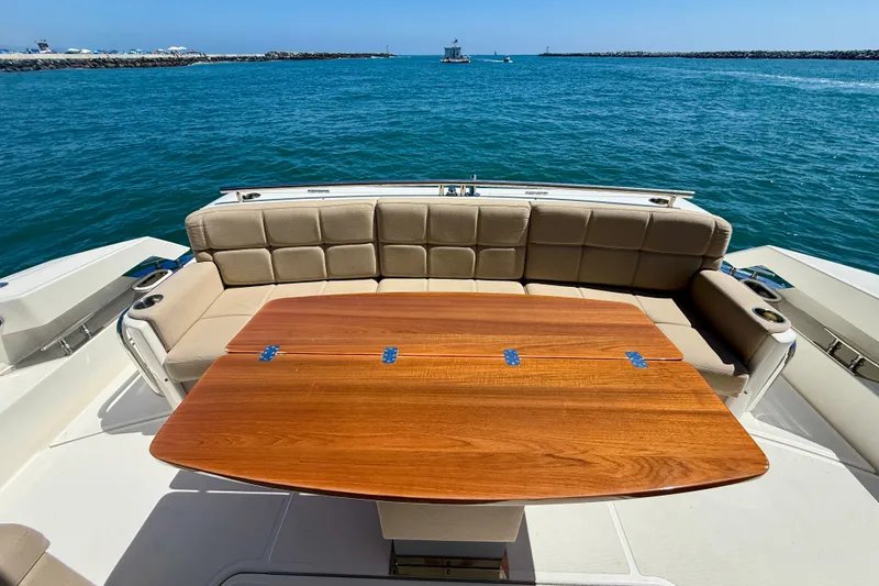 Slide: The Image of Luxurious 2015 Tiara Yachts 50 Coupe with elegant seating and wooden table, overlooking serene waters. - 76