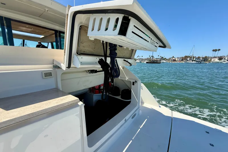Slide: The Image of 2015 Tiara Yachts 50 Coupe with open storage compartment, docked by the water. - 87
