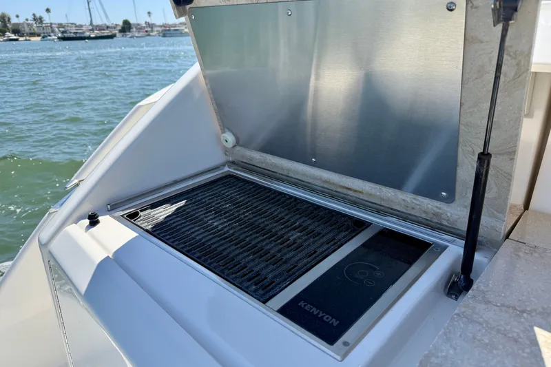 Slide: The Image of Outdoor grill on 2015 Tiara Yachts 50 Coupe, overlooking marina waters. - 85