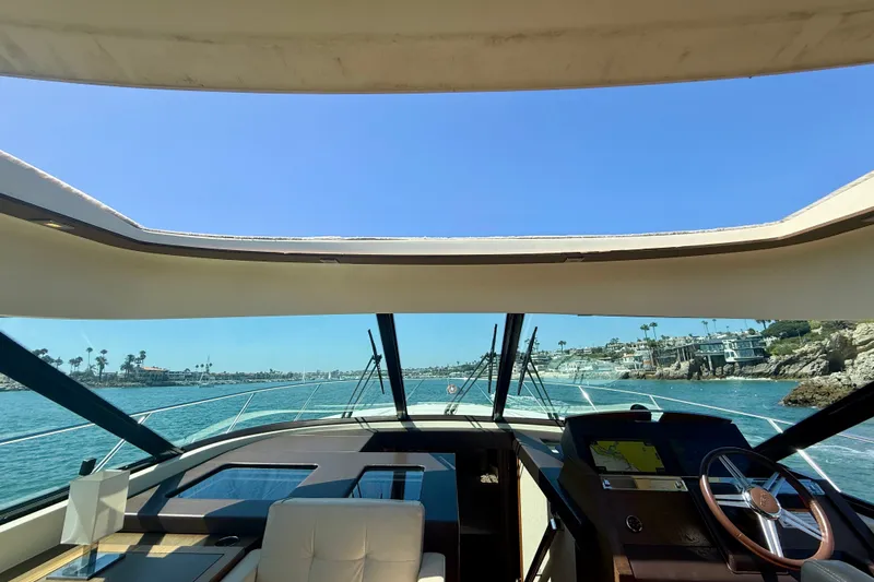 Slide: The Image of Interior view of 2015 Tiara Yachts 50 Coupe, showcasing helm and ocean scenery. - 22