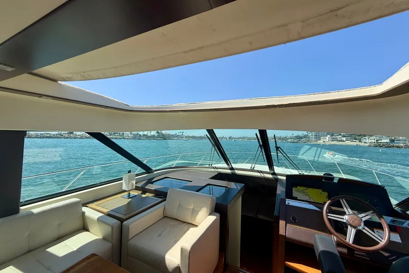 Slide: The Image of Interior view of 2015 Tiara Yachts 50 Coupe, featuring luxurious seating and panoramic windows. - 21