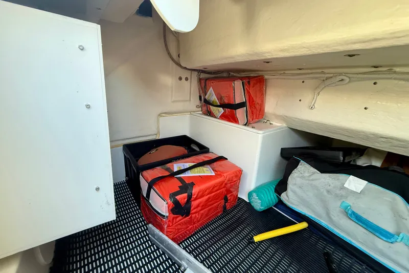 Slide: The Image of Storage compartment in a 2015 Tiara Yachts 50 Coupe with safety gear and bags. - 89