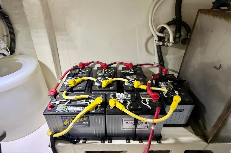 Slide: The Image of Battery setup in a 2015 Tiara Yachts 50 Coupe engine room, featuring interconnected cables. - 104
