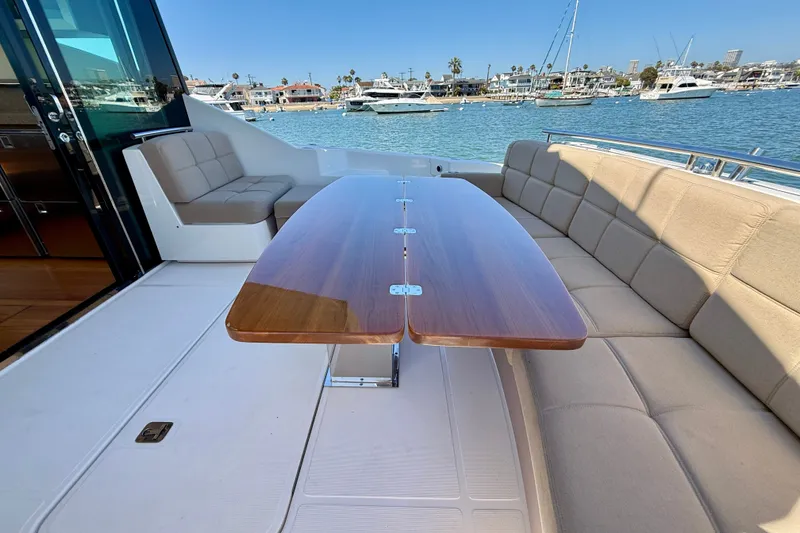 Slide: The Image of Outdoor seating area on a 2015 Tiara Yachts 50 Coupe, overlooking a marina. - 73