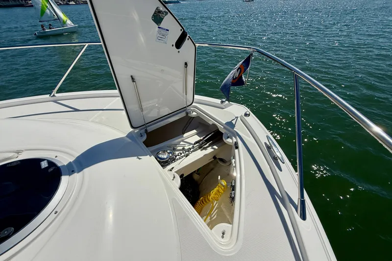 Slide: The Image of 2015 Tiara Yachts 50 Coupe bow storage compartment open on calm water. - 82