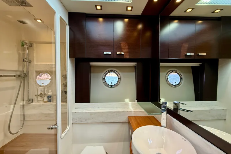 Slide: The Image of Luxurious bathroom interior of 2015 Tiara Yachts 50 Coupe with modern fixtures and porthole windows. - 68