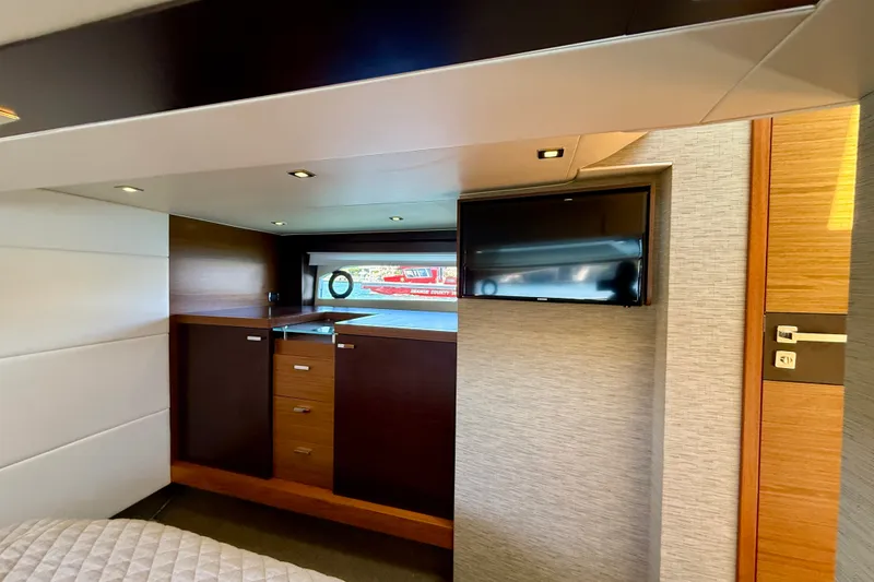 Slide: The Image of Luxurious interior of 2015 Tiara Yachts 50 Coupe with modern cabinetry and flat-screen TV. - 52