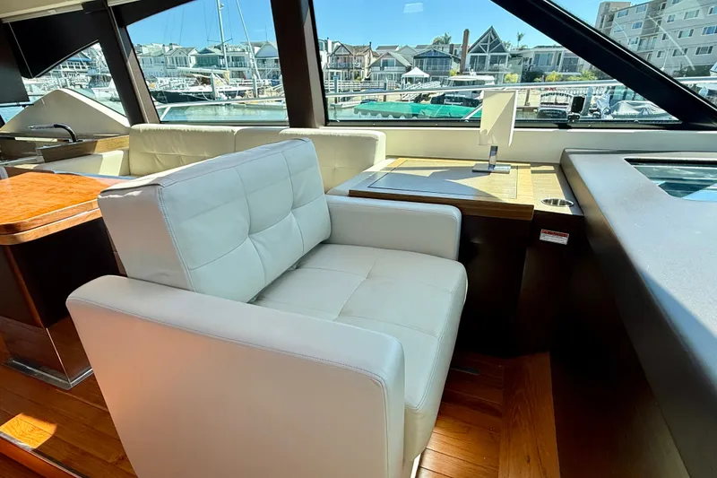 Slide: The Image of Luxurious interior of a 2015 Tiara Yachts 50 Coupe with plush seating and scenic marina view. - 17