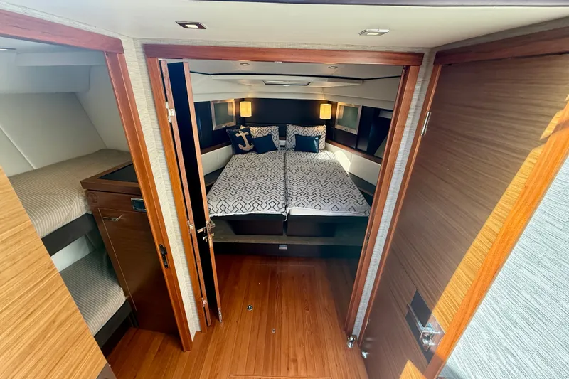 Slide: The Image of Luxurious 2015 Tiara Yachts 50 Coupe cabin interior with elegant bedding and wooden finishes. - 56
