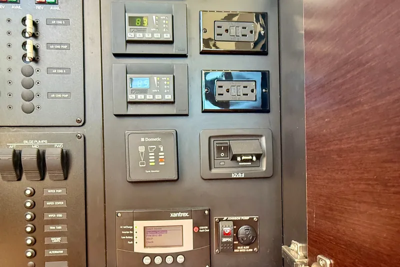 Slide: The Image of Control panel of a 2015 Tiara Yachts 50 Coupe, featuring various switches and monitors. - 36