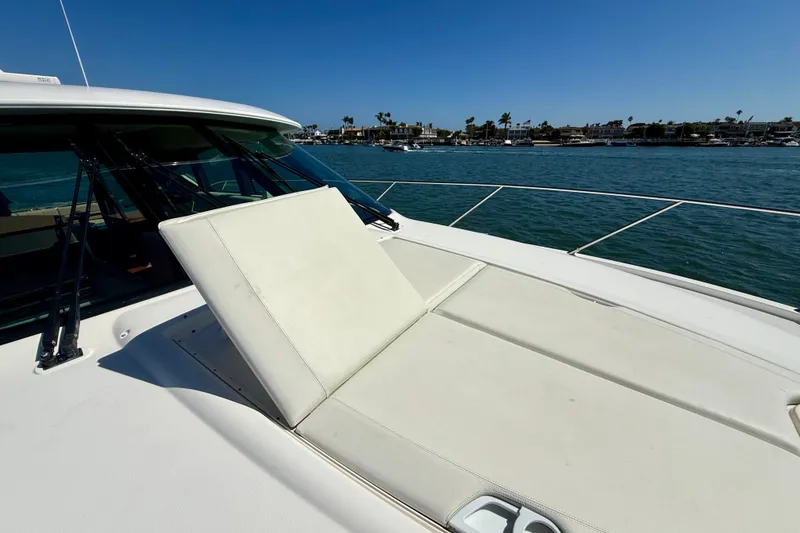 Slide: The Image of 2015 Tiara Yachts 50 Coupe with sunpad, docked in a scenic marina. - 80