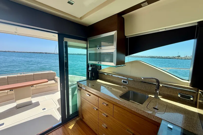 Slide: The Image of Luxurious 2015 Tiara Yachts 50 Coupe kitchen with ocean view and outdoor seating. - 23