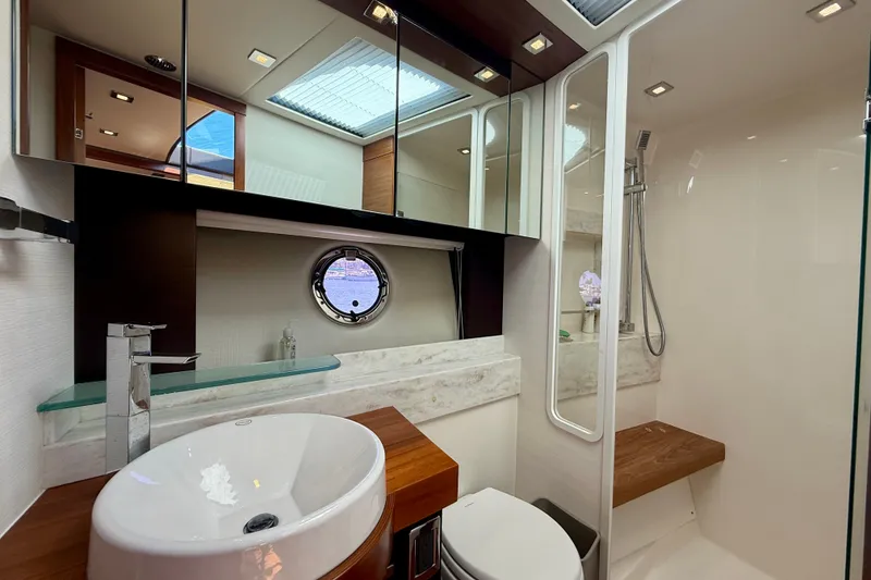 Slide: The Image of Luxurious bathroom interior of 2015 Tiara Yachts 50 Coupe with modern fixtures and porthole window. - 67