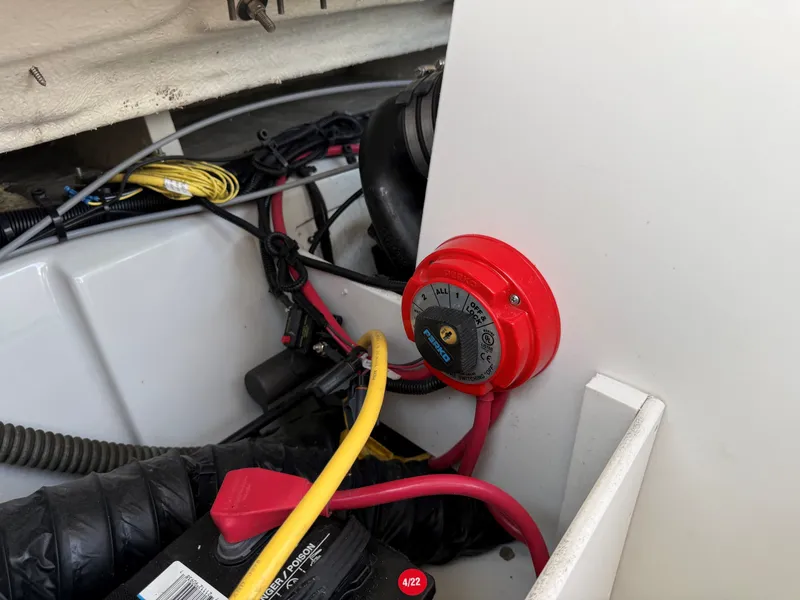 Slide: The Image of A red battery switch in a boat engine compartment with cables and hoses. - 25