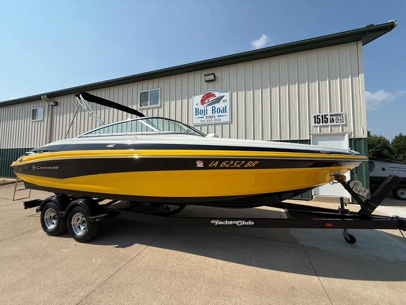 Slide: The Image of A yellow 2015 Crownline 235 SS boat on a trailer in front of a building. - 1