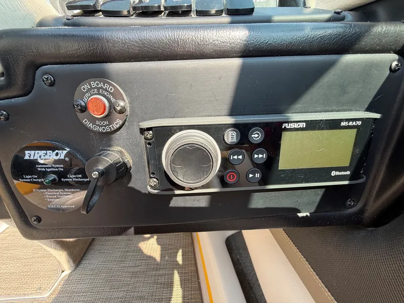 Slide: The Image of Close-up of a boat panel featuring a Fusion MS-RA70 radio and a fire extinguisher switch. - 21