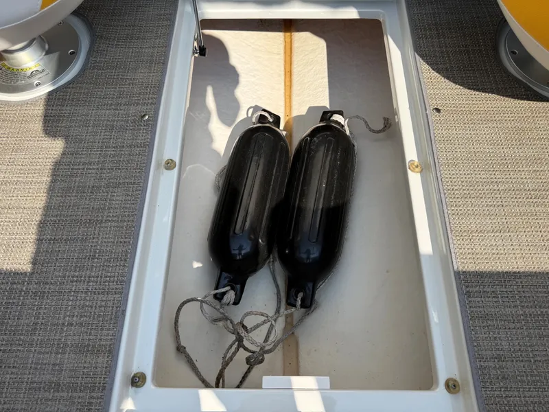 Slide: The Image of Two black boat fenders lie in an open storage compartment on a boat. - 19