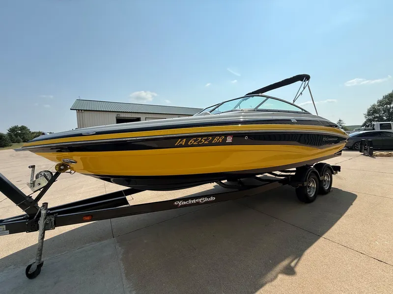 Slide: The Image of A yellow 2015 Crownline 235 SS boat on a trailer in a parking lot. - 2