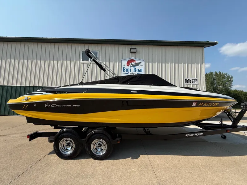 Slide: The Image of A yellow 2015 Crownline 235 SS boat on a trailer in front of a building. - 32
