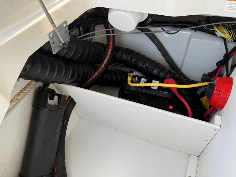 Slide: The Image of A view inside the engine compartment of a 2015 Crownline 235 SS boat with battery and wiring. - 26