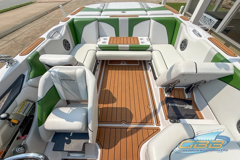 Slide: The Image of 2008 Nautique Super Air Nautique 210 interior with green and white seating, wood accents. - 22