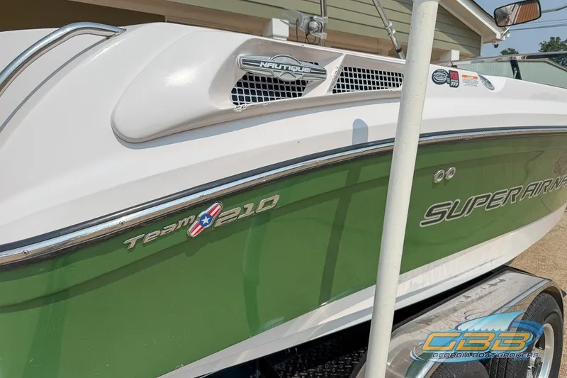Slide: The Image of 2008 Nautique Super Air Nautique 210 boat with green and white exterior. - 7
