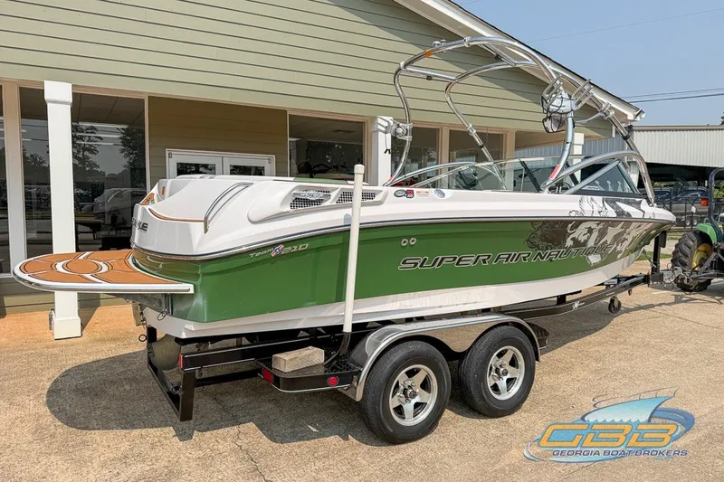 Slide: The Image of 2008 Nautique Super Air Nautique 210 boat on trailer, green and white design. - 6