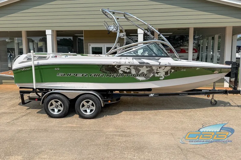 Slide: The Image of 2008 Nautique Super Air Nautique 210 boat on trailer, green and white design. - 5