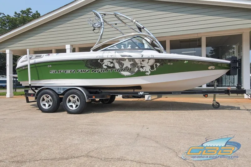 Slide: The Image of 2008 Nautique Super Air Nautique 210 boat on trailer, green and white design. - 10