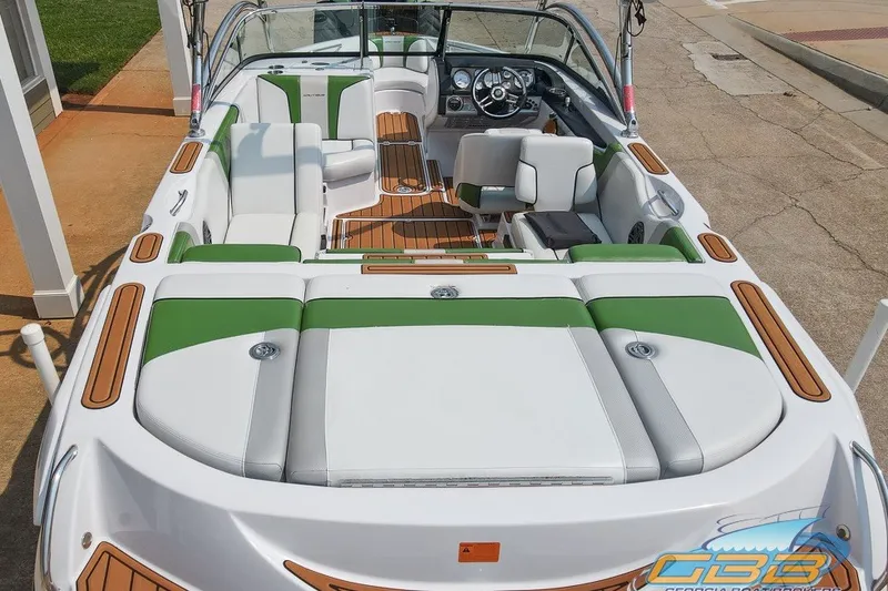 Slide: The Image of 2008 Nautique Super Air Nautique 210 boat with green and white interior, docked. - 8