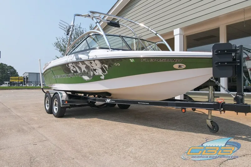 Slide: The Image of 2008 Nautique Super Air Nautique 210 boat on trailer, green and white design. - 9