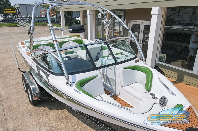 Slide: The Image of 2008 Nautique Super Air Nautique 210 boat with green and white interior, parked on trailer. - 15