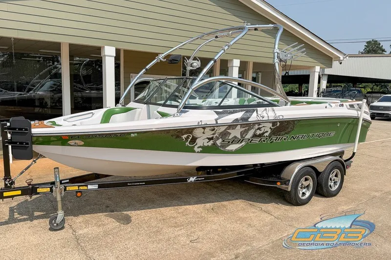 The Image of 2008 Nautique Super Air Nautique 210 boat in green and white on a trailer. - 0