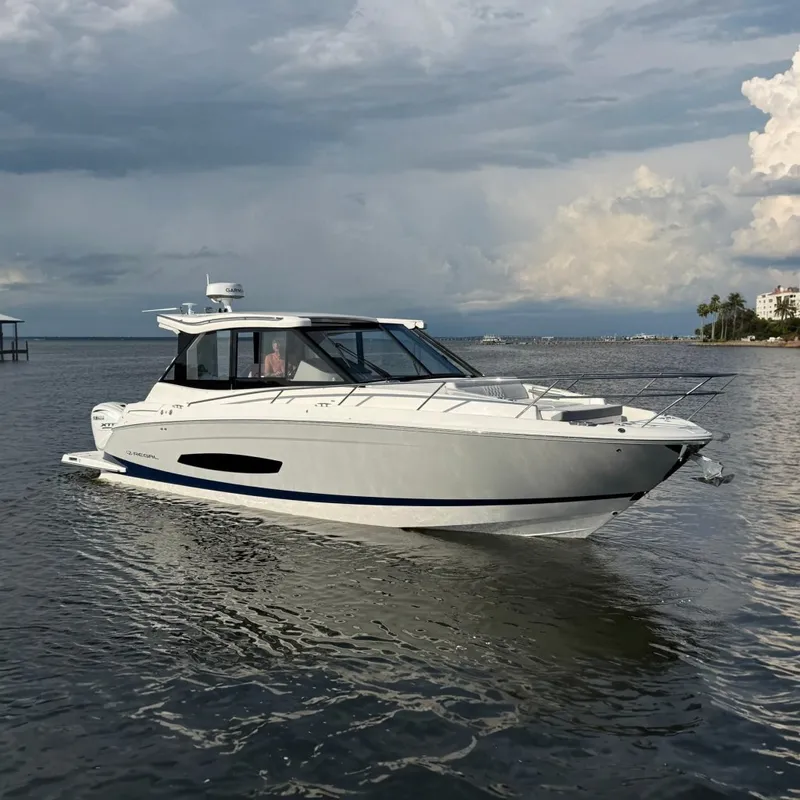The Image of 2025 Regal 36 XO luxury yacht on calm waters under a cloudy sky. - 0