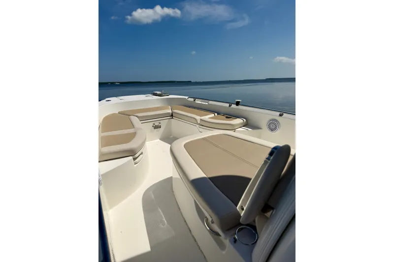 Slide: The Image of 2017 Boston Whaler 270 Dauntless boat interior with beige seating, under clear blue sky. - 14