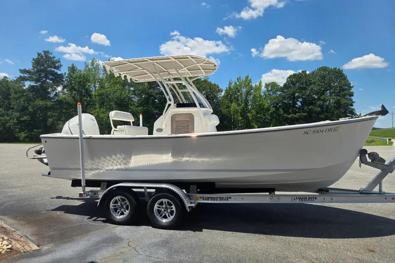Slide: The Image of 2021 Vanquish 23 CC boat on trailer under clear blue sky. - 5