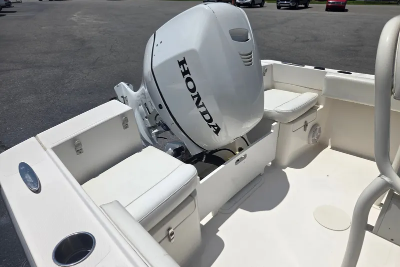 Slide: The Image of Vanquish 23 CC 2021 boat with Honda outboard motor, featuring white seating and deck. - 8