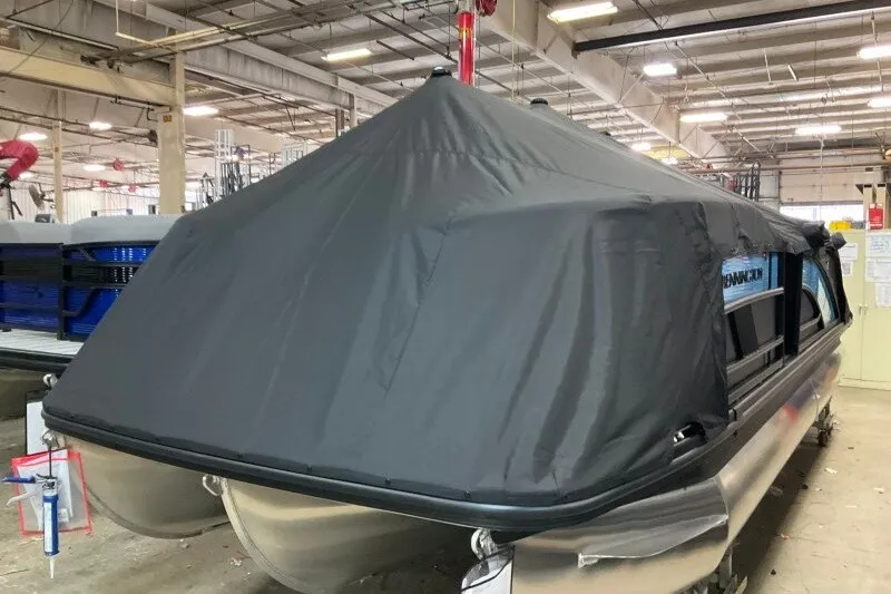 Slide: The Image of 2027 Bennington 22 M Swingback pontoon boat covered in a protective tarp indoors. - 7