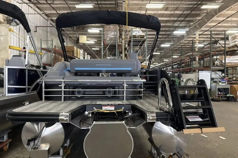 Slide: The Image of 2027 Bennington 22 M Swingback pontoon boat in a warehouse setting. - 5
