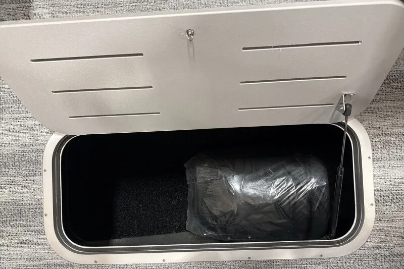 Slide: The Image of Open storage compartment in a 2027 Bennington 22 M Swingback boat. - 18