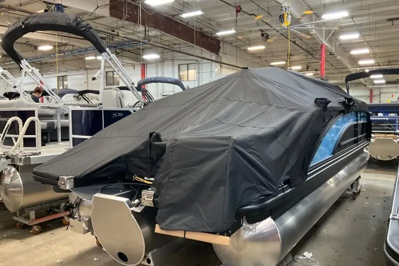 Slide: The Image of 2027 Bennington 22 M Swingback pontoon boat covered in a factory setting. - 9