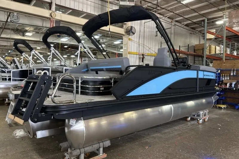 Slide: The Image of 2027 Bennington 22 M Swingback pontoon boat in a warehouse setting. - 2