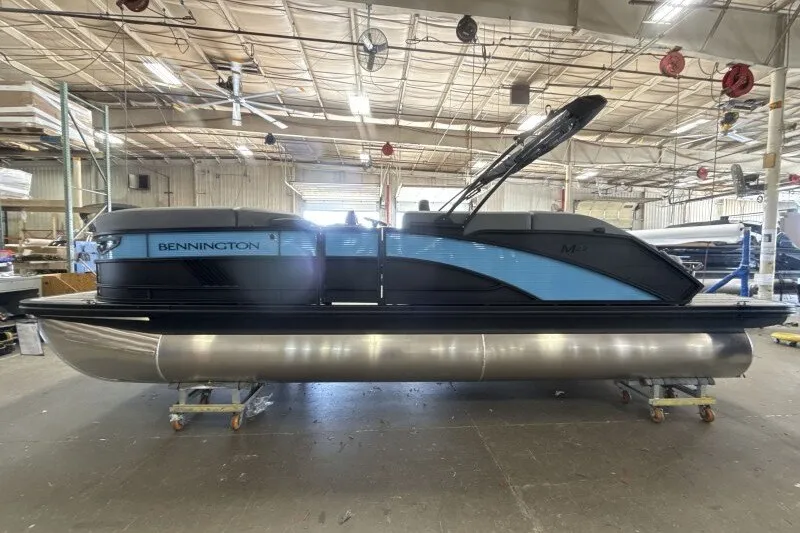 Slide: The Image of 2027 Bennington 22 M Swingback pontoon boat in a warehouse setting. - 4