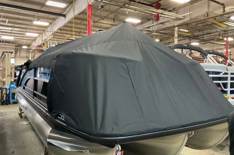 Slide: The Image of 2027 Bennington 22 M Swingback pontoon boat with cover in a factory setting. - 6