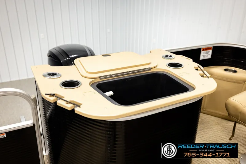 Slide: The Image of 2018 Bennington SX RF boat interior with beige seating and storage compartments. - 28